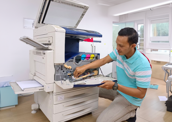 MACROMAC technician servicing a premium refurbished photocopier machine